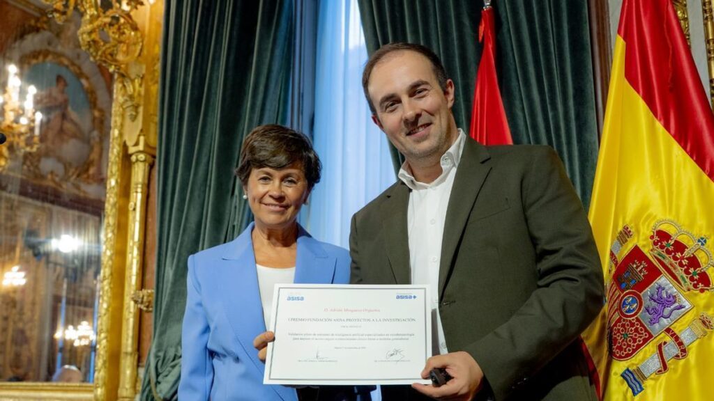 Adrián Mosquera, investigador del IDIS, sostiene el diploma del I Premio Fundación Asisa Proyectos a la Investigación